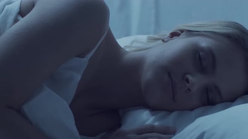 Blonde Woman Asleep in Bed at Night