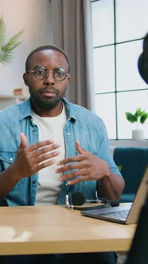 Man Speaking to Camera at Desk with Laptop