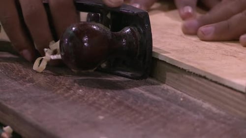 Woodworker Smoothing Wood with Hand Plane Close-up