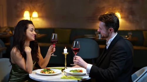 Happy Romantic Couple Clinking with Wine Glasses While Enjoying Dinner in the Restaurant Lifestyle