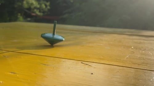 The Green Spinning Top Still Spinning on the Table While Other Fell