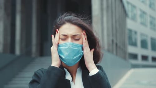 Woman Wearing Face Mask with a Headache