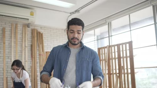 Carpenters are working at woodshop.