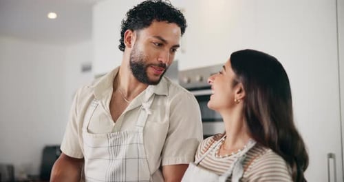 Young Couple Smiling at Each Other in Kitchen