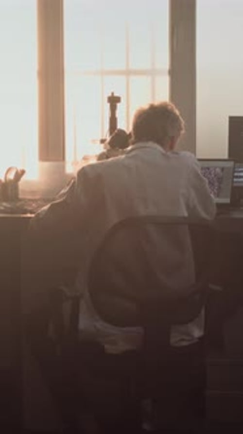 Scientist Working with Microscope in Bright Lab