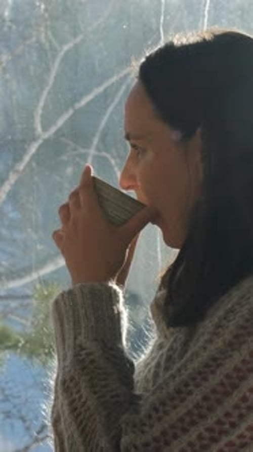 Relaxed Woman Sipping Hot Herbal Tea at a Cafe