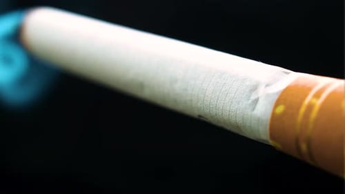 full fresh cigarette is lighten up by the lighter and left to be burned without smoking POV view ext