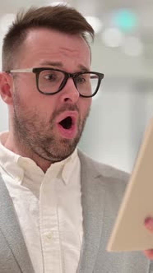 Man Using Tablet Displays Shocked Expression