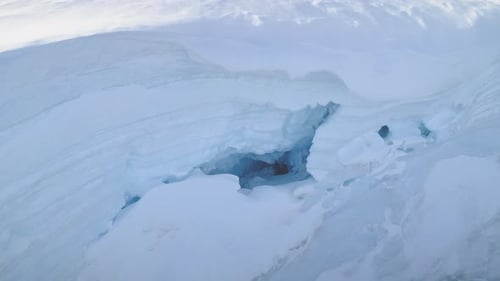 Blue Ice Cave in White Glacier on Antarctic Peninsula Aerial Shot Closeup