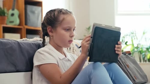Kid Using Tablet to Draw Picture Sitting on Floor Indoors