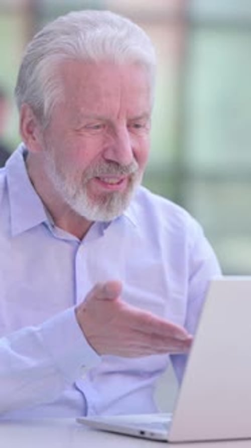 Senior Man Video Calling on Laptop Indoors