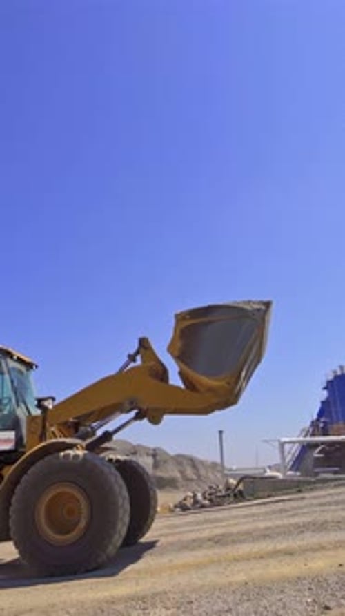 Fondo contemporáneo de fábrica de asfalto. La excavadora transporta el asfalto a tanques especiales al aire libre