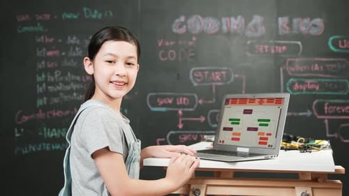 Asiatischer Student programmiert technischen Code mit Geräten auf dem Tisch. Erbauung