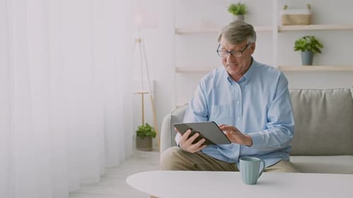 Man Using Tablet Device Relaxing at Home