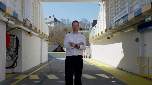 Smiling captain approach and pose in front of camera at ferry car deck