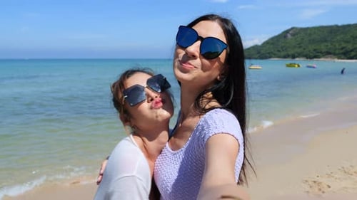 Beautiful young woman standing on beach and taking selfie smile