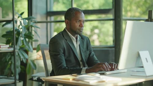 Man Working in Office Rubs Eyes