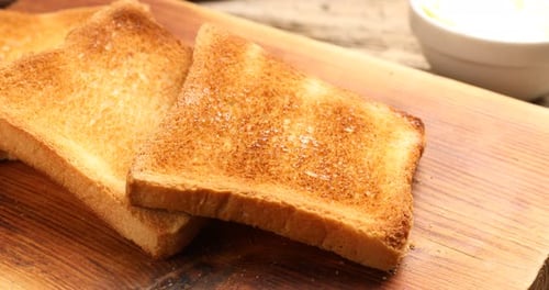 Buttered Toast on Wooden Board For Breakfast