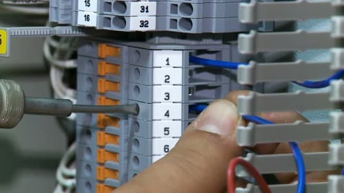 Technician Wiring an Electrical Panel with Wires