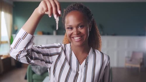 Young Happy African American Woman Shows Off Key to New Apartment or House
