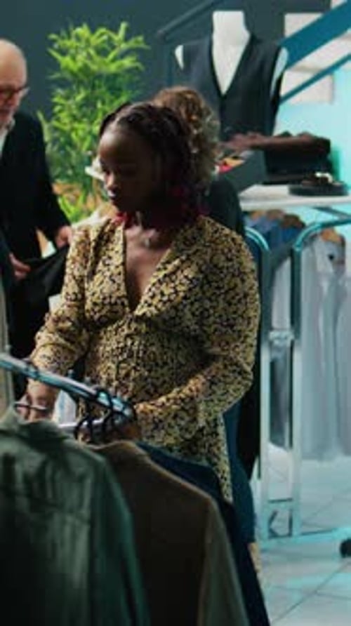 Woman Browsing Clothing Rack in Fashionable Boutique