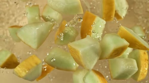 Des morceaux de melon volent sur un fond clair filmés par une caméra à haute vitesse à 1000 images par seconde