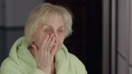 Senior Woman Applying Lotion to Her Face