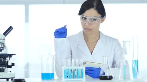 Woman Scientist Writing Notes in Bright Laboratory