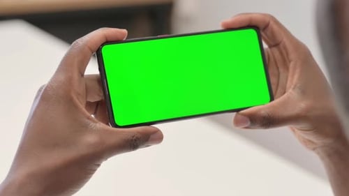 Close up of African Man Holding Horizontal Smartphone with Chroma Key