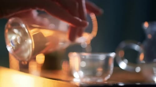 Pouring Light Liquid into a Glass Teacup