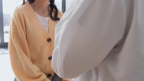 Doctor Examining Patient Using Stethoscope in Hospital Room