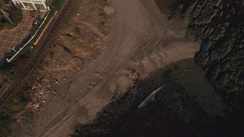 Luftaufnahme eines felsigen Strandes, der sich in der Nähe einer städtischen Küste zum Horizont neigt