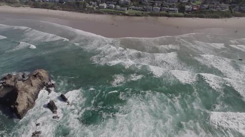 Ocean waves rush past Haystack Rock and crash onto Cannon Beach