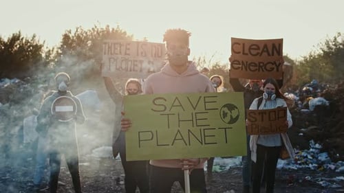 Group Holds Signs at Landfill Site