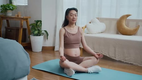 Pregnant Woman Meditating on Yoga Mat at Home