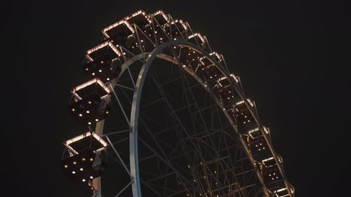 Bright Ferris Wheel Turning Spinning at Night at a Amusement Park