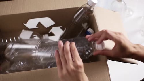 Plastic Bottles Being Placed in a Recycling Box