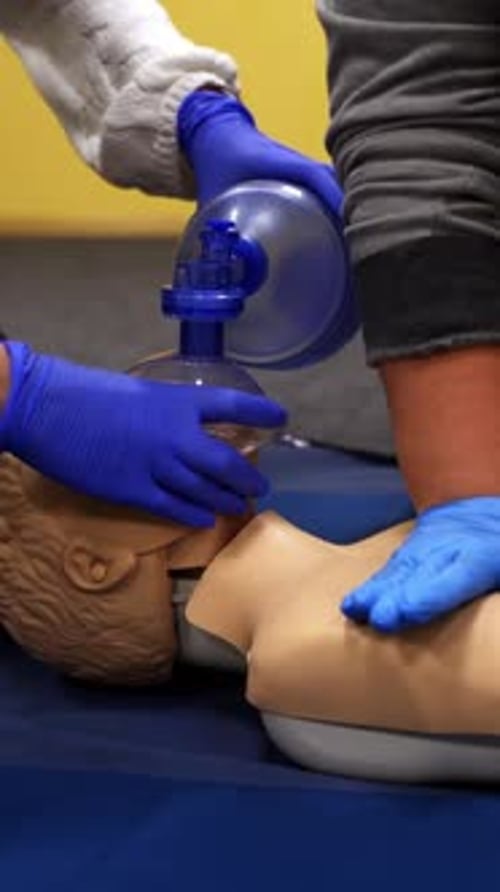 Practicing CPR Techniques on Medical Dummy in Lab