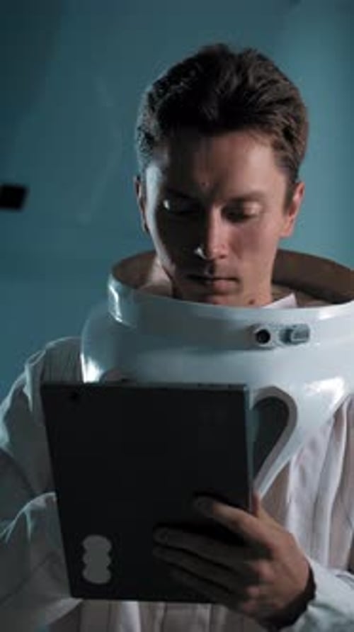 Vertical of A Man in an Astronaut Costume with an Electronic Tablet