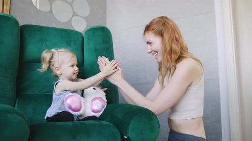 Woman and Child Playing Hand Game Together