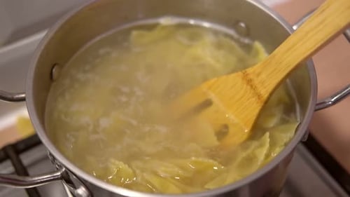 Pasta Boiling in a Pot with Wooden Spoon