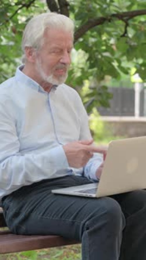 Senior Man Video Calling on Laptop in Park
