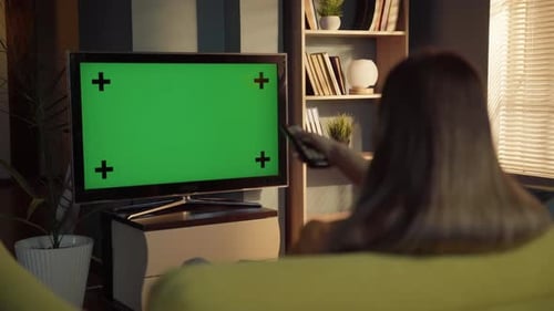 Woman with Remote Watching TV with Green Screen