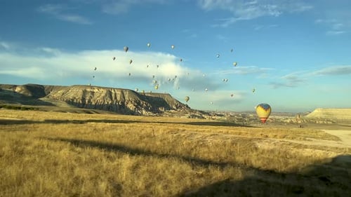 At sunset, we're driving through a field in Cappadocia, and in the distance, hot air balloons.