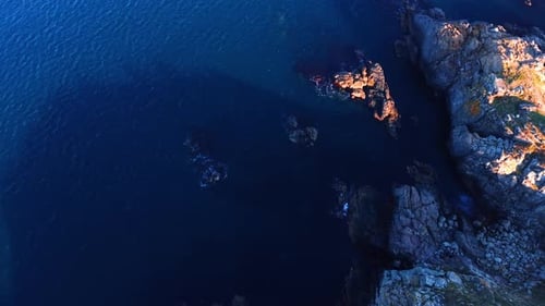 Blue waterscape meeting the rocky shore.