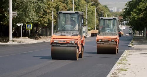 Road Building Asphalt Paver is Laying a New Layer of Asphalt Roadway Repair