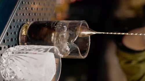 Bartender Prepares Cocktail with Ice and Strainer