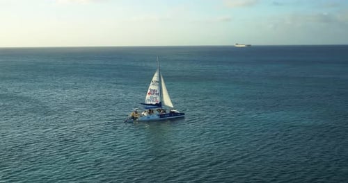 Palm Beach, Noord, Aruba - June 20 2016: Sailboat Along Coast In Ocean At Sunrise, Aerial Drone