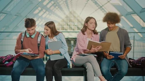Studierende sprechen, während sie auf der Bank in der Universitätshalle sitzen