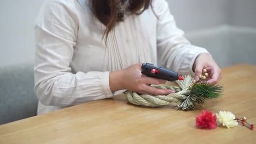 Woman Crafting Decorative Wreath at Home